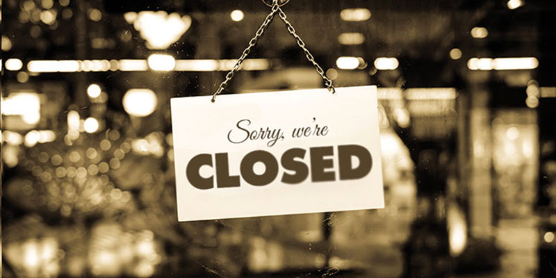 A closure sign of a restaurant hanged on the door