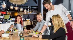 زيادة مشاركة العملاء في المطاعم: نادل يقدم الطعام للزبائن ويتفاعل معهم