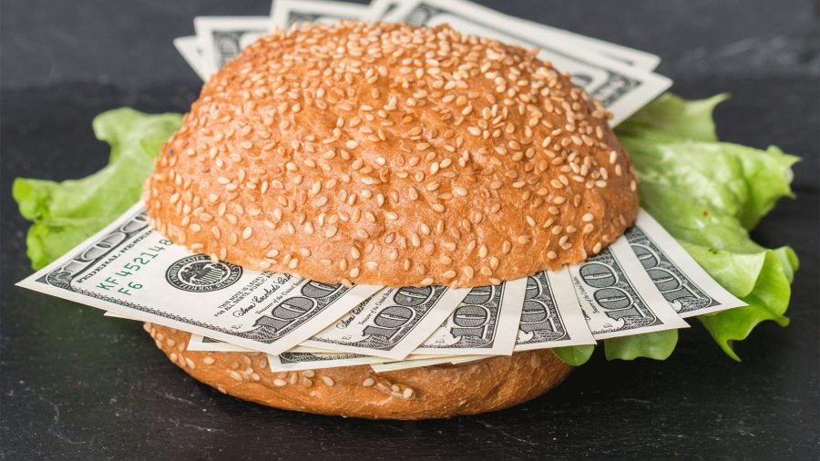 A picture of a burger with dollar bills inside of it indicating food inflation