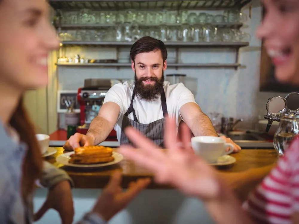 A happy waiter working at a restaurant