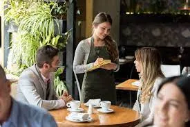 A waiter serving people at a restaurant