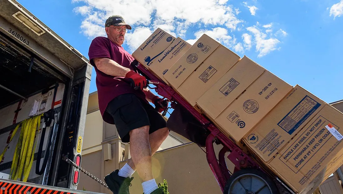 Food supply shortage and an employee carrying food boxes in the truck
