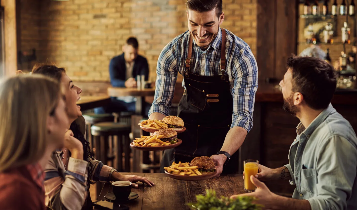 A waiter serving customers at a restaurant