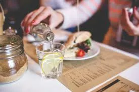 A customer pouring water in a restaurant 