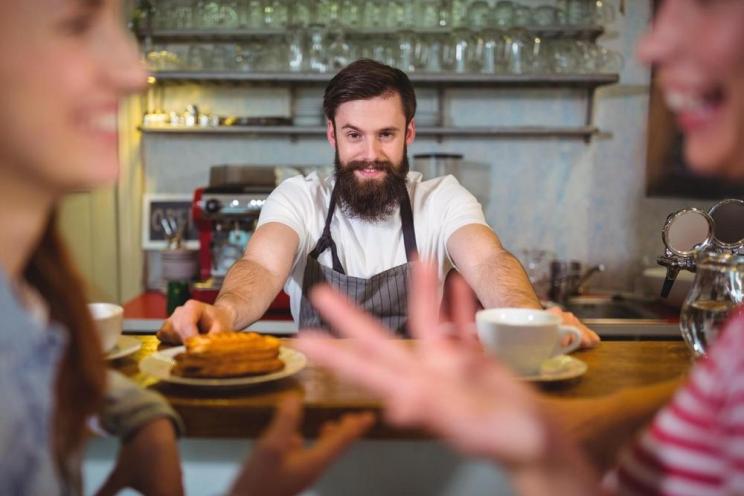 A happy waiter working at a restaurant 