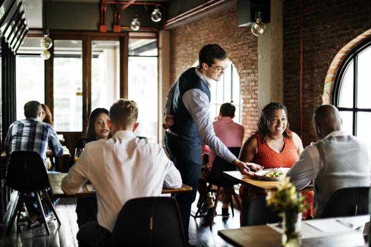 A restaurant full of customers and a waiter serving his section