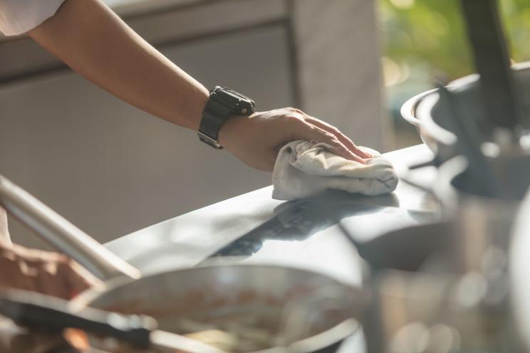 A chef cleaning and disinfecting the counter