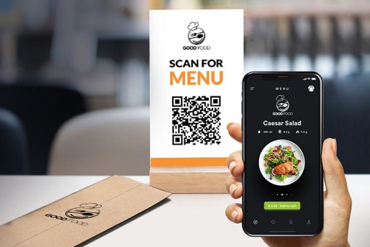 يقوم الزبون بمسح رمز QR ليستكشف قائمة الطعام