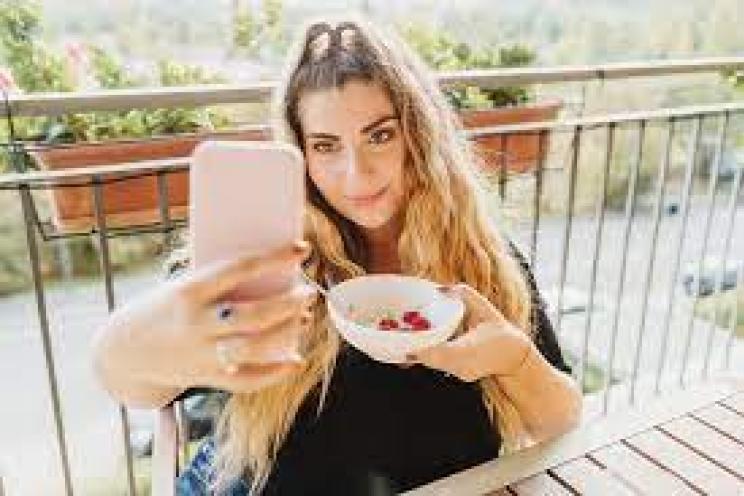 A picture of Gen Z customer taking a selfie while eating