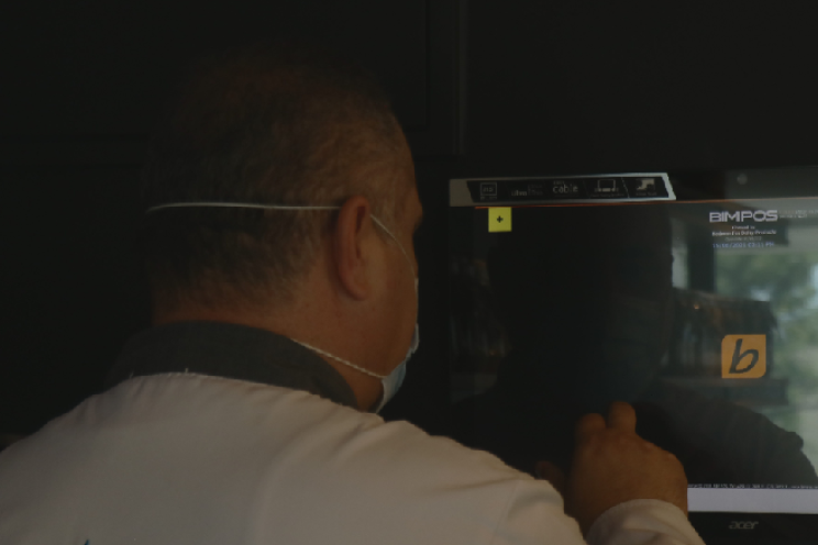 an employee working on the POS software at a restaurant