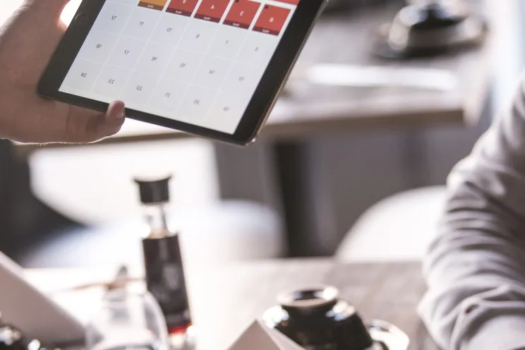A waiter taking the order from the customer on a tablet