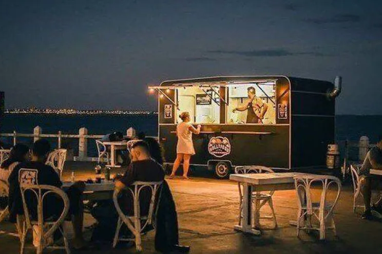 A food truck operating seasonally at night and serving customers food