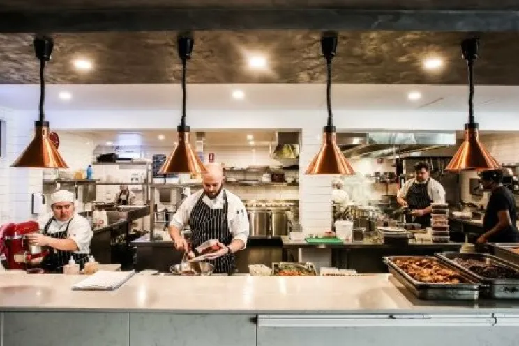 Employees and chefs working and preparing food at the restaurant’s kitchen
