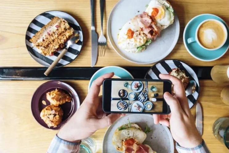 A food influencer is taking pictures from restaurants