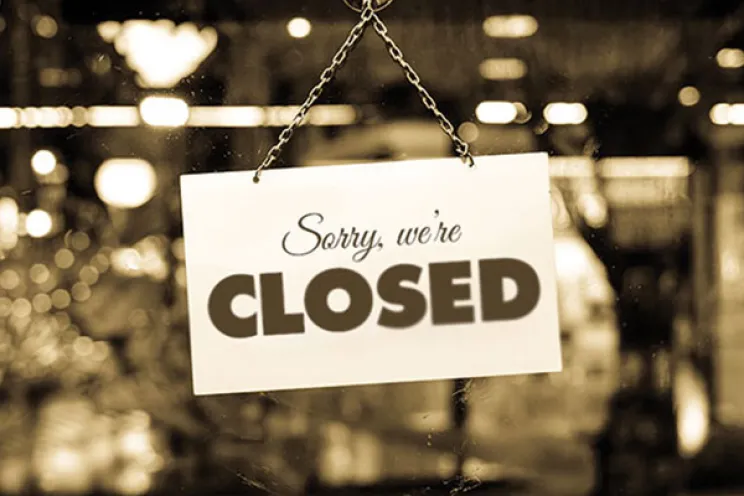 A closure sign of a restaurant hanged on the door