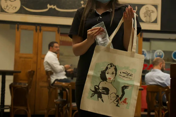 Café Youness tote bag held by a customer 