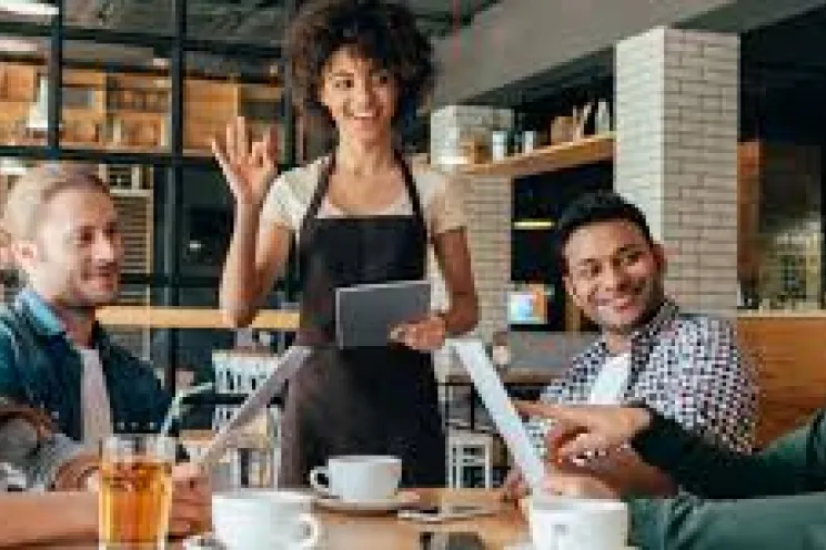 A waiter serving customers at their table