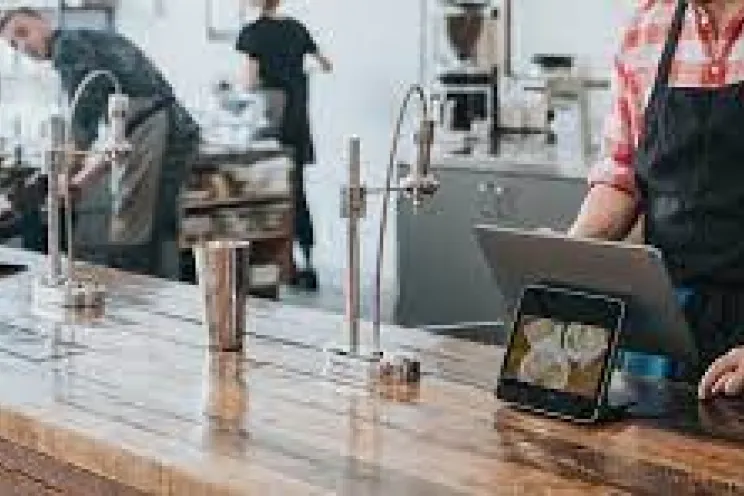 موظف يخدم الزبائن عبر برنامج نقاط بيع