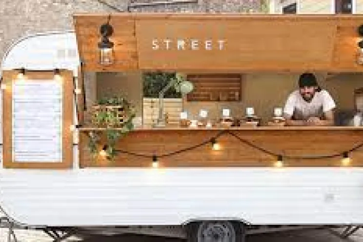 An employee serving people in a food truck business