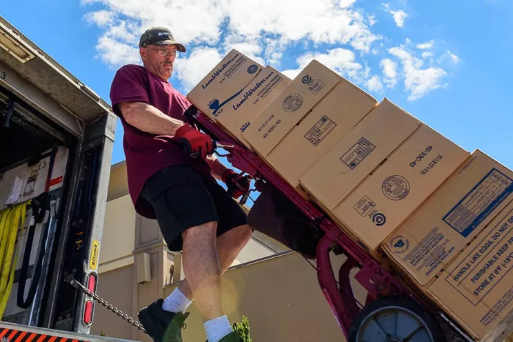 Food supply shortage and an employee carrying food boxes in the truck