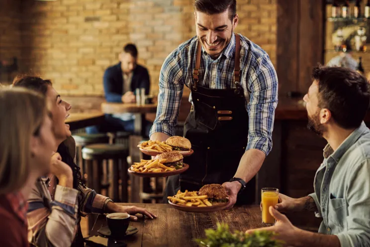 A waiter serving customers at a restaurant 
