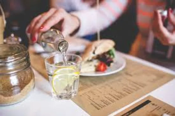 A customer pouring water in a restaurant 