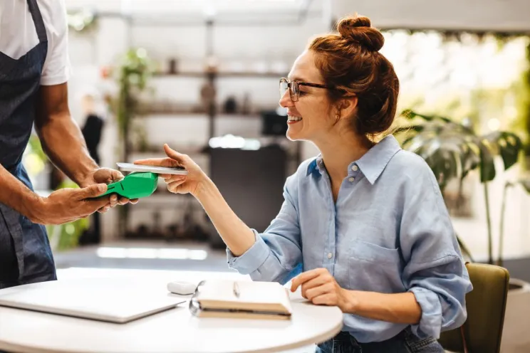Increase customer loyalty through CRM: a waiter serving a happy customer