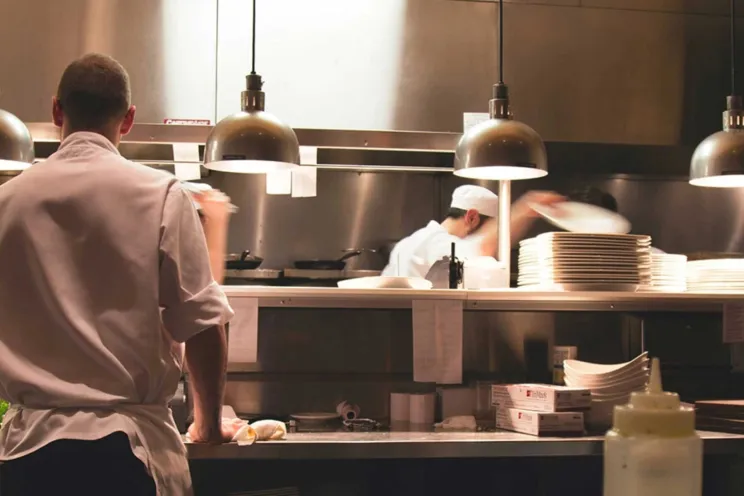 an employee or a chef working in the kitchen and preparing food