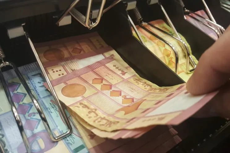 Cashier cashing in lebanese money from cash drawer in a super market